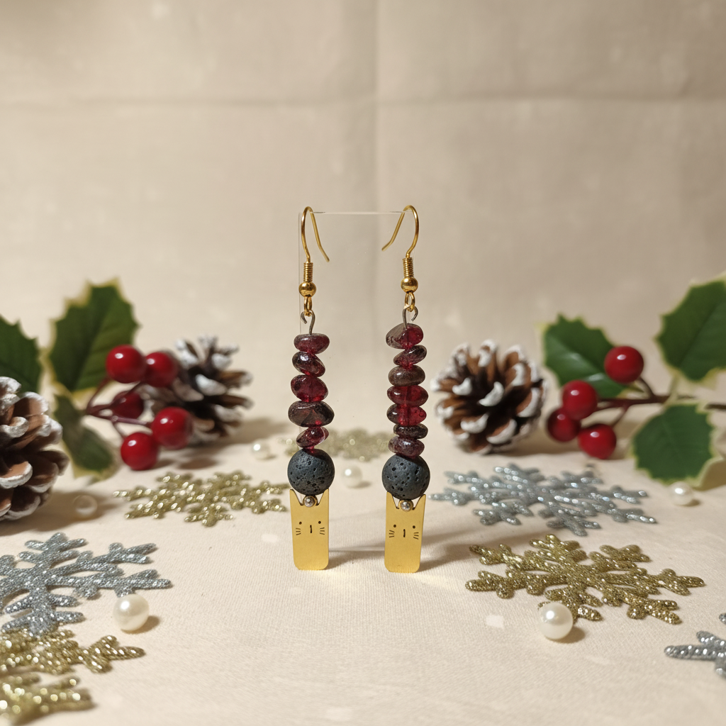 Delicate handmade earrings featuring a charming gold-plated cat adorned with natural Lava stone and Garnet.