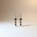 Delicate handmade earrings featuring a gold-plated heart, natural Lava stone, Garnet, and stainless steel beads. 